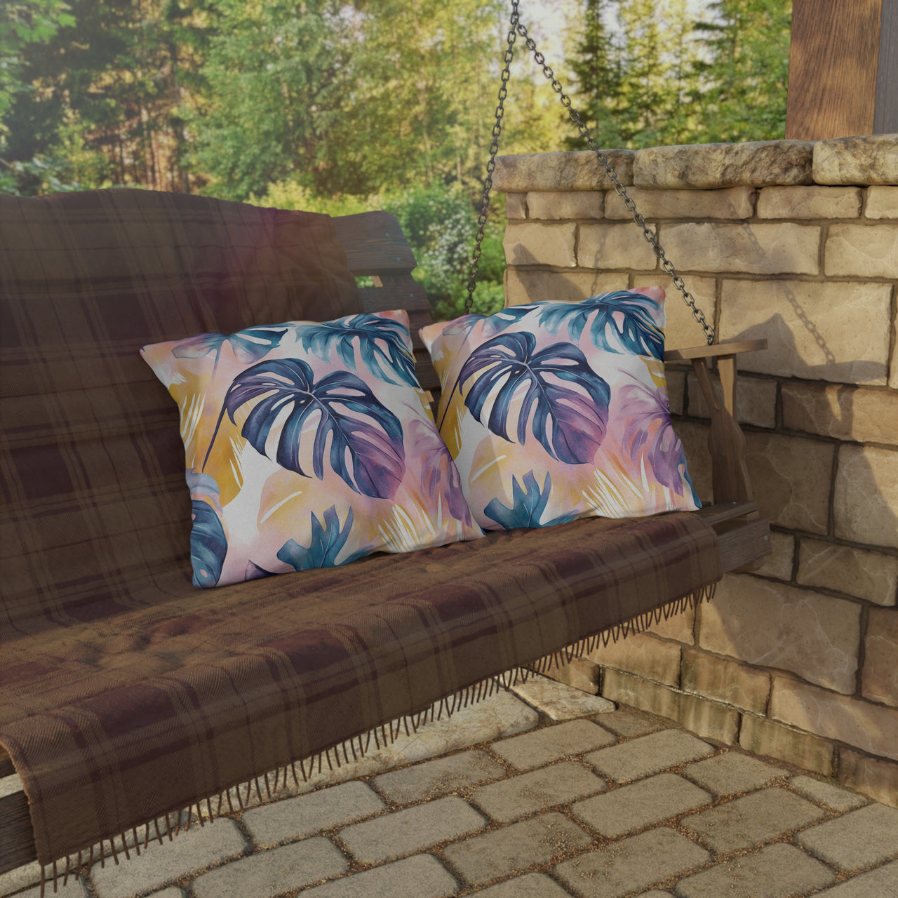 Wooden swing with colorful leaf-patterned cushions on a stone patio.